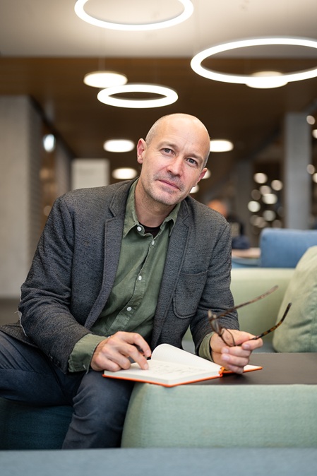 Foto des Gründers von make possible marc keller sitzende auf einem sofa beim verfassen von notizen in ein notizbuch